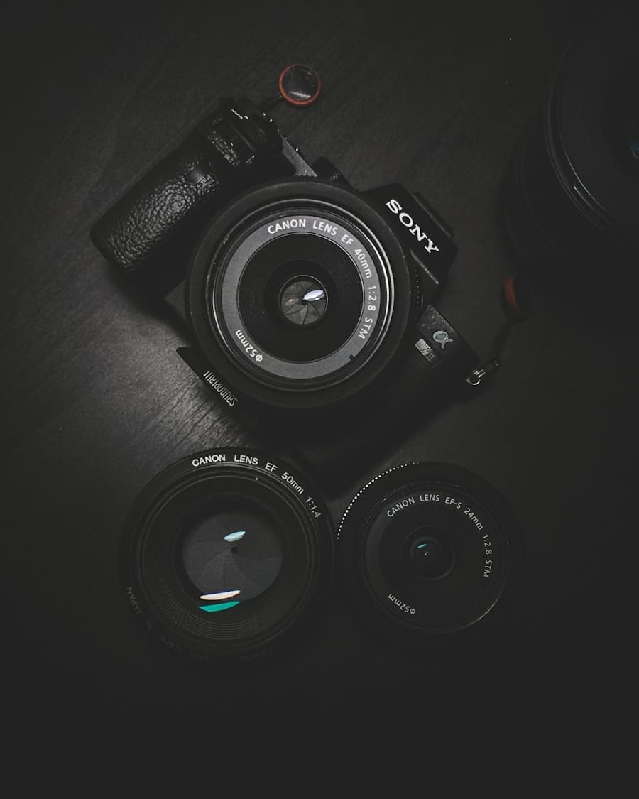 A camera body and two lenses arranged on a dark surface
